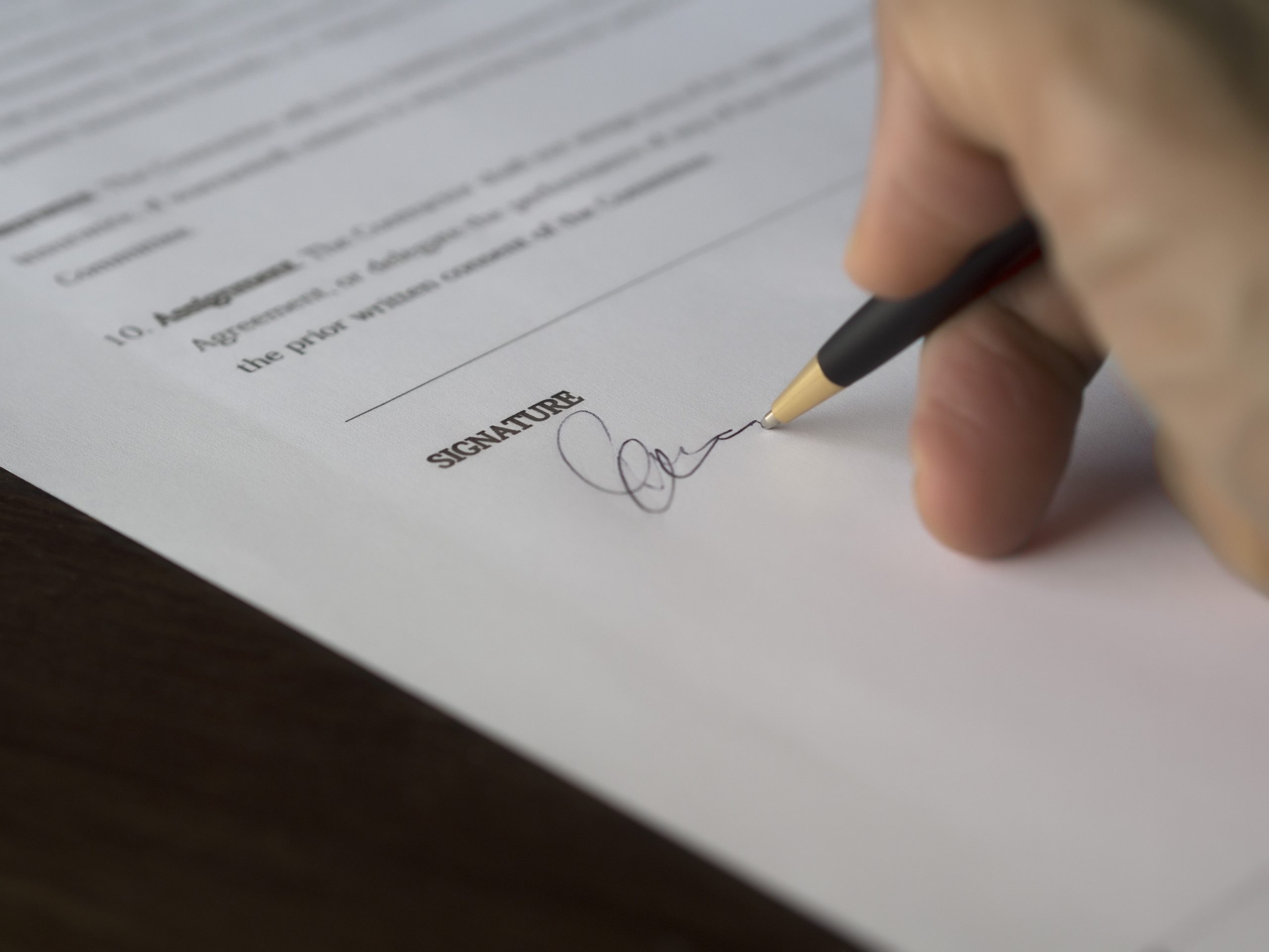 Close up of hand signing a document